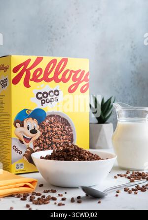 LONDON,UK - MAY 28, 2025: Chocolate coco pops breakfast cereal in bowl plate with spoon and milk jar on kitchen table. Stock Photo