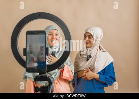 Muslim women hosting a live podcast or social media broadcast Stock Photo