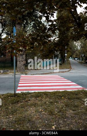 Red Bitumen Footpath The sign symbolizing a pedestrian path is painted white on the black ...