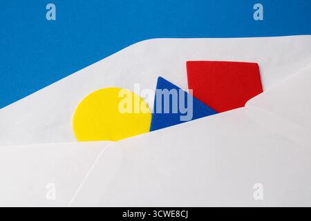 Yellow circle, blue triangle, and red square. White envelope sending colorful geometric figures Stock Photo