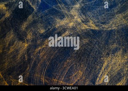 Abstract background with golden strokes on dark blue texture. Textured surface with strokes, highlights and iridescence. Stock Photo