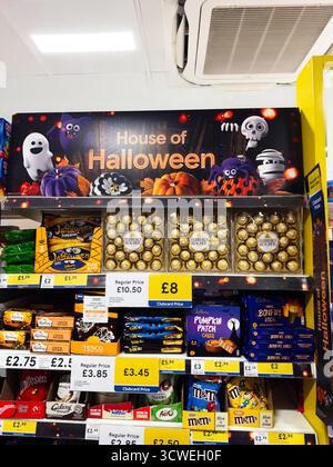 Manchester, UK - September 26, 2025: Bright Halloween themed candy Tesco shelves showcase seasonal treats and gift boxes for shoppers. Stock Photo