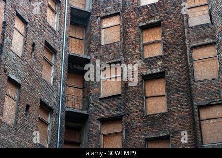 Abandoned brick building with boarded-up windows Stock Photo