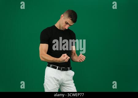 Collection of videos with fit European man in black t shirt and white pants on green chroma key background expressing various emotions smiling thinking surprised serious and confident poses. Stock Photo