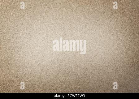 Background of beige suede matte fabric closeup. Velvet matt texture of beige nubuck textile Stock Photo