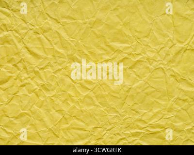 Bright yellow matte detail crumpled paper texture. Blank page pattern or background for winter season Christmas festival card, new year designs, text Stock Photo
