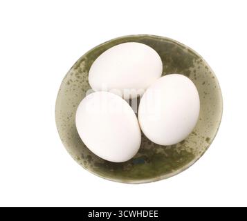 Three eggs in brown bowl, isolated on white background Stock Photo