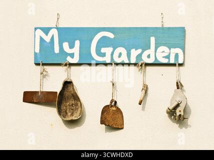 Old gardening tools as decoration hang on white wall Stock Photo