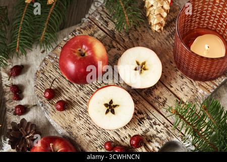 Two halves of a red apple with a star in the middle, with Christmas tree, dried rose hips and decoration Stock Photo