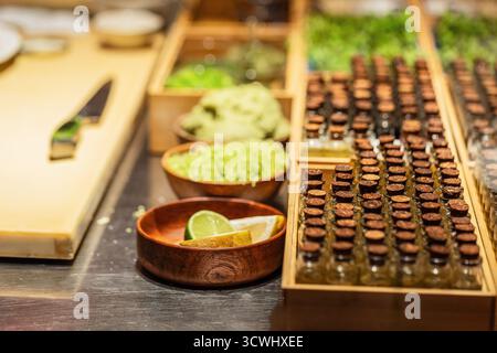 Fresh ingredients and condiments are beautifully arranged on a kitchen countertop, showcasing vibrant colors and textures for culinary preparation. Stock Photo