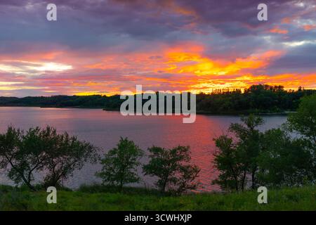 Dramatic clouds and color in the sunset over Lake Minnewasta, Morden, Manitoba, Canada. Stock Photo