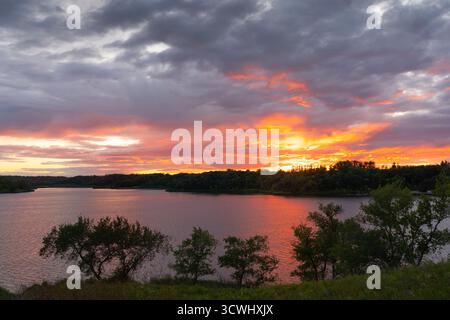 Dramatic clouds and color in the sunset over Lake Minnewasta, Morden, Manitoba, Canada. Stock Photo