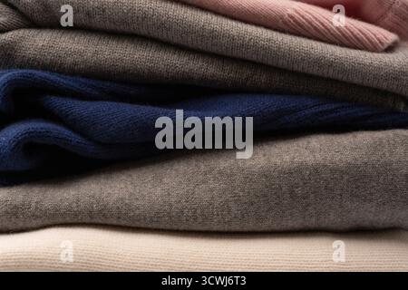 A group of warm sweaters isolated on a white background. Stack of folded sweaters on white background. Stock Photo
