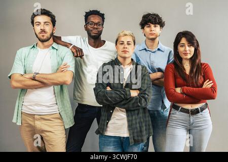 A multi-ethnic group of five serious and determined young adults from generation z standing together as a team and looking directly at the camera with Stock Photo