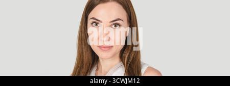 Young caucasian female with brown hair and green eyes in white attire against neutral background. Stock Photo