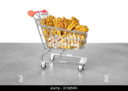 Walnuts in a miniature shopping cart, selective focus. Stock Photo