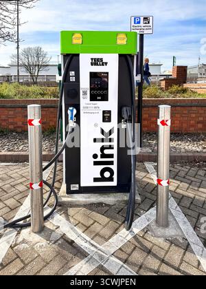 Electric vehicle charging station with Blink branding in a parking lot, featuring a charging point and surrounding area. Stock Photo
