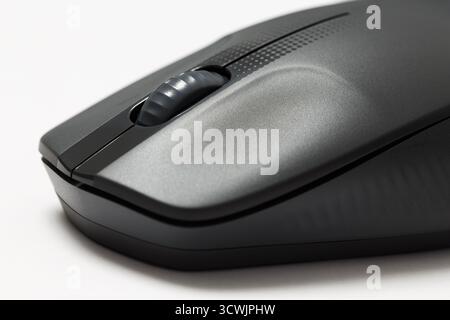 A modern wireless ergonomic computer mouse on a white background. Close-up fragment Stock Photo