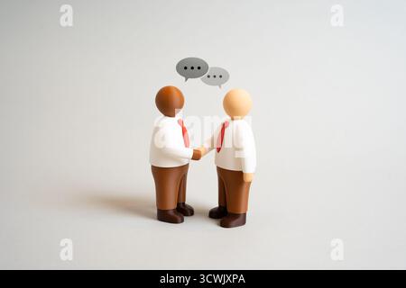 Two businessmen shake hands and engage in dialogue. Business meeting. Discussing business. Partnership, negotiation, and agreement. Trust, collaborati Stock Photo