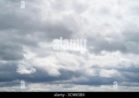 Dramatic cloudy sky with grey and white cumulus clouds on overcast day Stock Photo