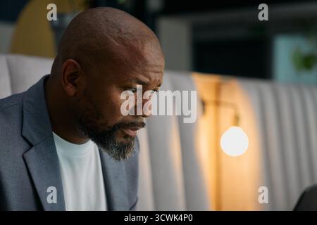 Side view of serious mature businessman working in office lounge Stock Photo