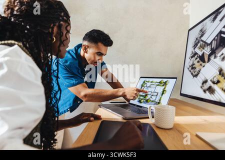 Two professionals engage in collaborative architectural design work, using advanced technology and innovative tools. Their teamwork displays expertise Stock Photo