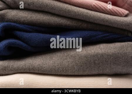 A group of warm sweaters isolated on a white background. Stack of folded sweaters on white background. Stock Photo