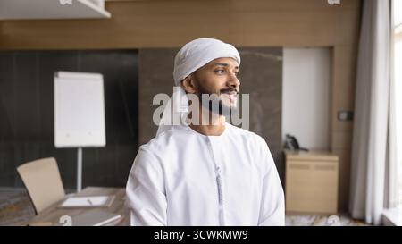 Smiling young Arabian man stand in boardroom dream about success Stock Photo