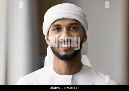 Head shot portrait young Arabic man wearing kandura headscarf keffiyeh Stock Photo