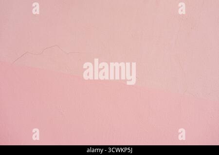 Pastel pink painted wall with subtle surface cracks and soft light gradient. Concept of imperfection, softness, minimalist design backdrop, copy space Stock Photo