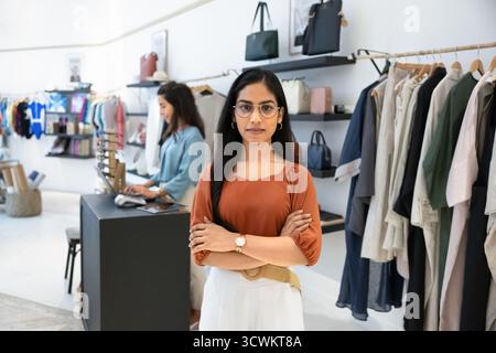 Confident young Indian retail store manager woman posing in showroom Stock Photo