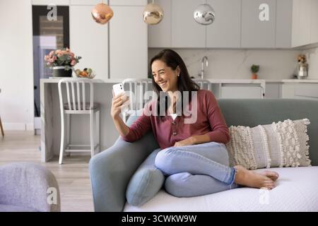 Happy young Hispanic woman talking on video call Stock Photo