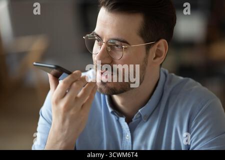 Closeup portrait young businessman speaking on phone using voice app Stock Photo