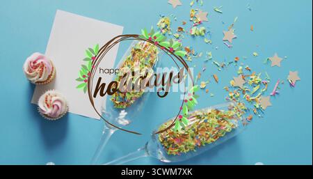 Image of happy holidays text over champagne glasses with stars and cupcakes on blue background Stock Photo