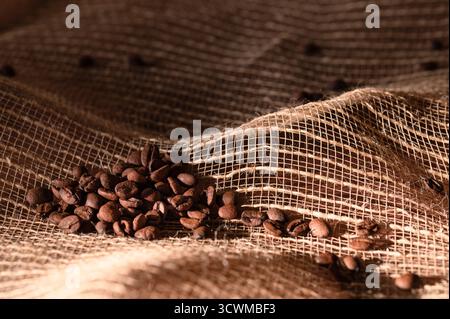 Whole roasted coffee beans on a burlap sack Stock Photo