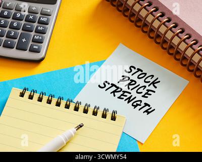 Stock price strength concept on sticky note with calculator, notepad and pen on colorful background Stock Photo