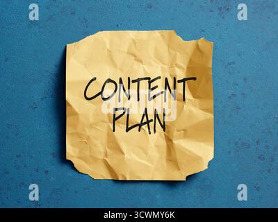 Content plan is written on a crumpled yellow note paper, representing marketing strategy Stock Photo