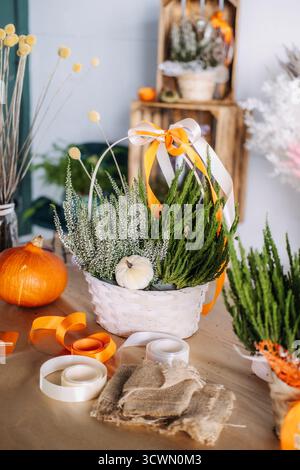 Decorated Thanksgiving table with floral gift baskets, pumpkins, and natural craft materials in a rustic setting. Seasonal centerpiece ideas, harvest Stock Photo