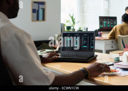 Black Man Developing Mobile Application Interface on Laptop Computer Stock Photo