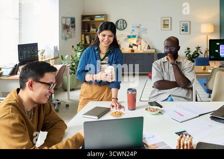 Multiethnic Adults Collaborating on Project in Modern Office Workspace Stock Photo