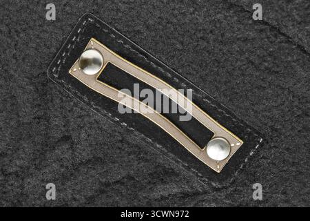 Empty clothes patch tag label stitched on black wool background Stock Photo
