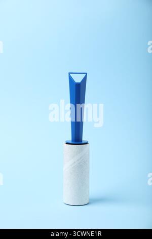 One lint roller on light blue background Stock Photo
