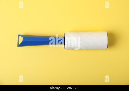 One lint roller on yellow background, top view Stock Photo