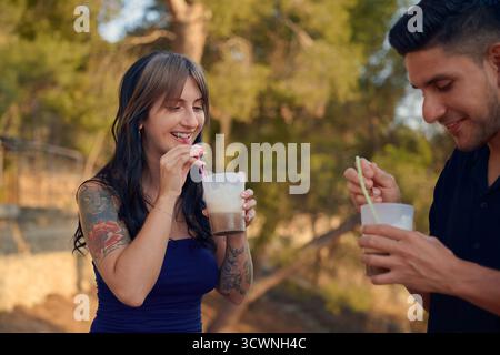 Young couple enjoying iced coffee drinks outdoors Stock Photo