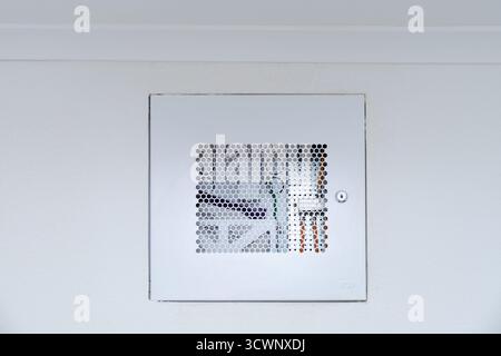 Wall mounted electrical distribution box with ventilation grille and lock. Home wiring system and network equipment enclosure. Stock Photo