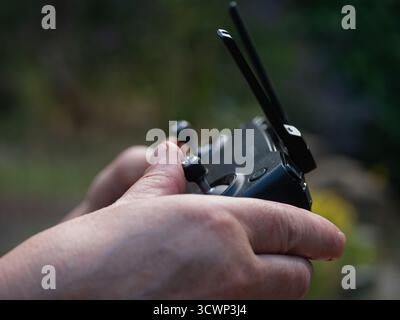 Hands with drone and remote controller in background  Stock Photo