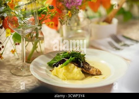 Fried zander fillet in breading with mashed potatoe and vegetables. Crispy white fish fry on the festive table. Stock Photo