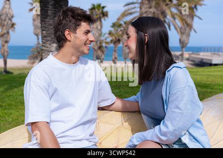 Young couple outdoors sitting together smiling romantic lifestyle moment Stock Photo