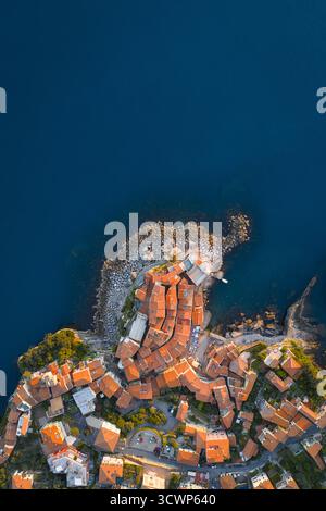 Aerial view of terracotta rooftops cascading down to the azure sea, a timeless Italian village hugging the rocky coastline, Tellaro, Liguria, Italy. Stock Photo