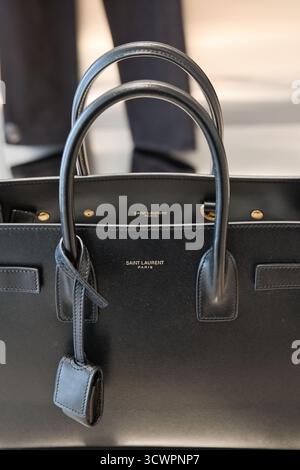 Yves Saint Laurent feminine black leather bag in a store, close up Stock Photo